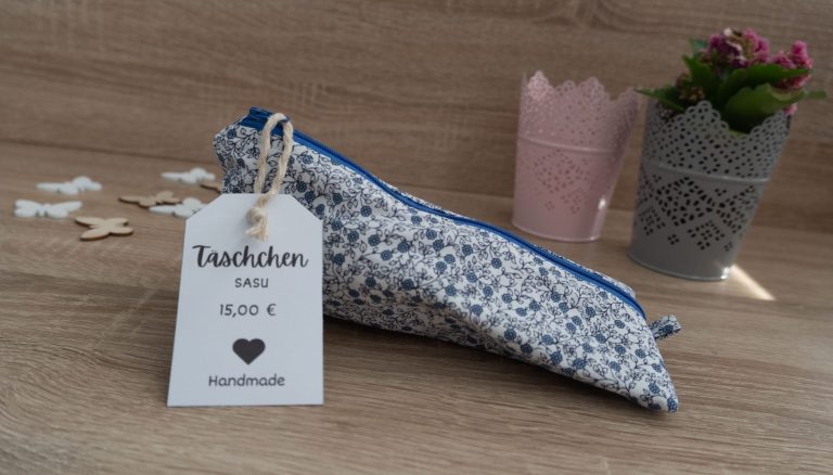 Bunt gemusterte Pencilcase mit Preisschild und dekorativer Pflanze im Hintergrund.